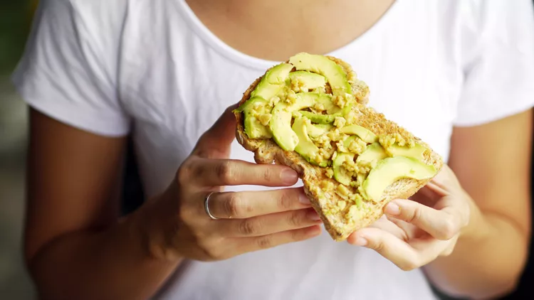 woman hand show eating avocado bread cheese toast white t-shirt background