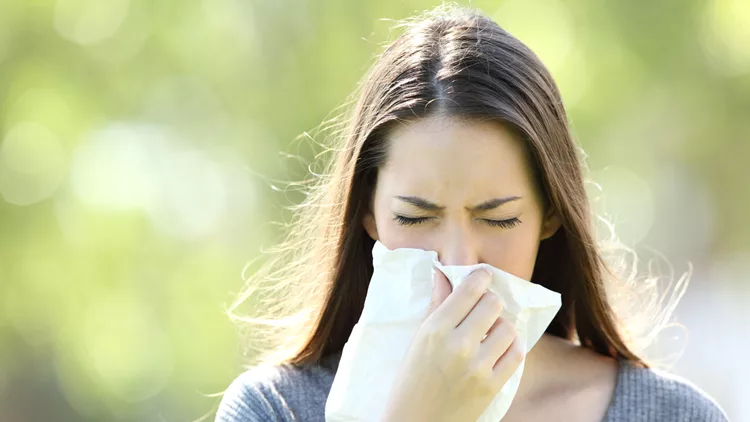 Girl sneezing and blowing in a wipe