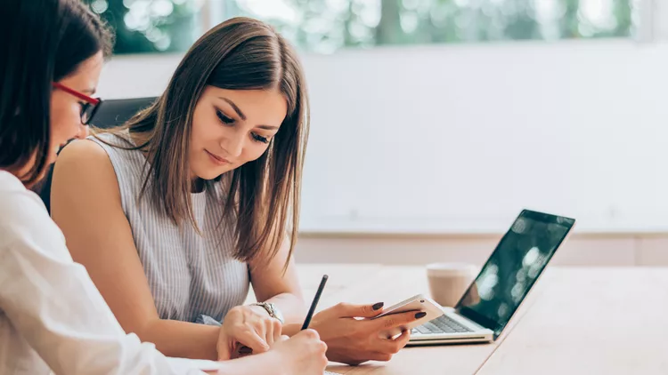 Two female colleagues in office working together.