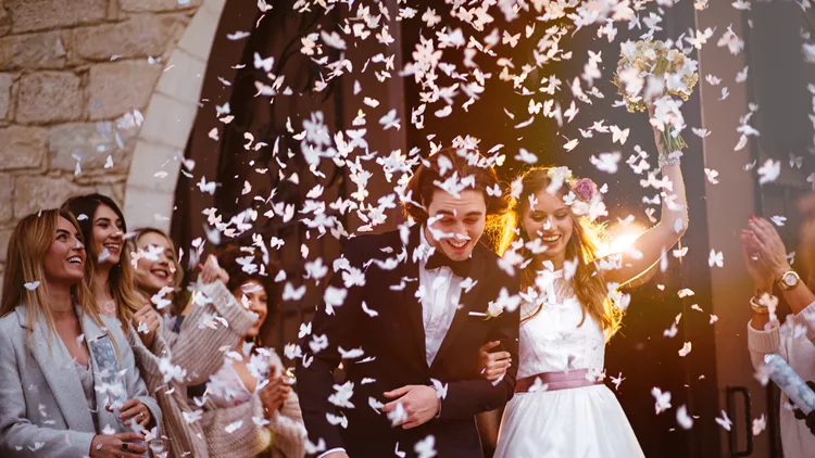 Happy bride and groom leaving church and celebrating