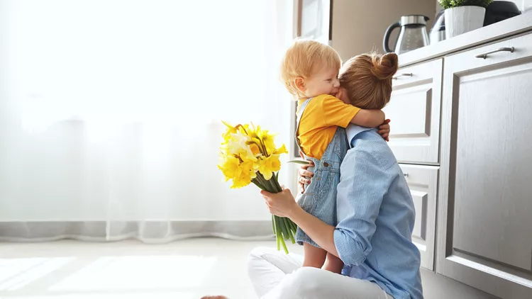 happy mother's day! baby son gives flowersfor  mother on holiday