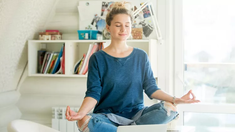 portrait-of-an-attractive-woman-at-table-lotus-pose-picture-id612737138