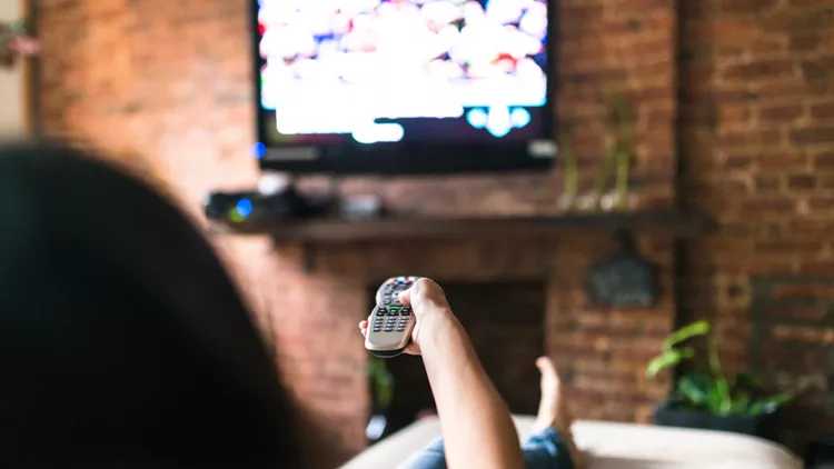 woman relaxing online on sofa reading some papers