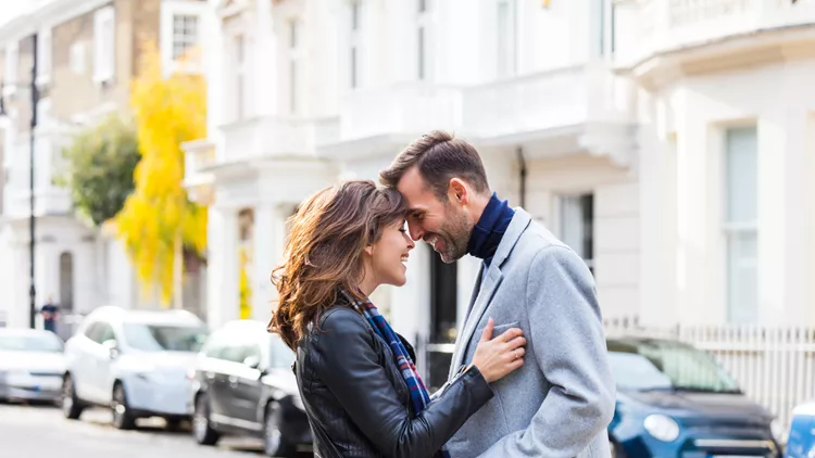 Happy romantic couple flirting in the city street