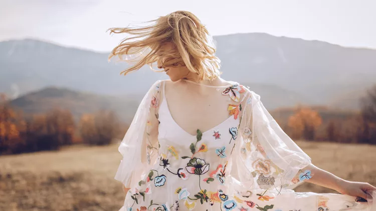 Beautiful hippie woman dancing in a meadow