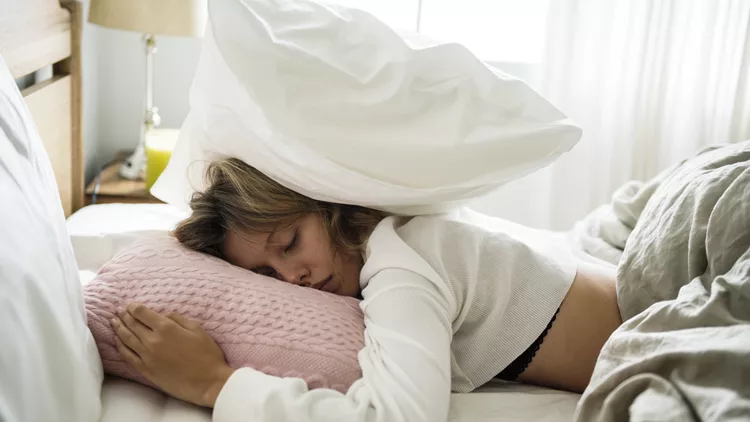 A Caucasian woman sleeping on her bed