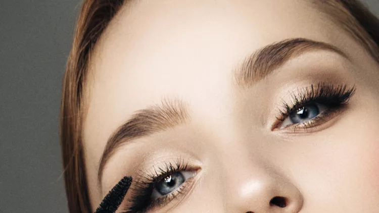 Beautiful woman applying mascara