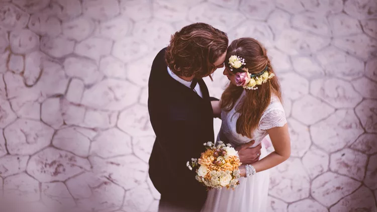 Affectionate bride and groom embracing and dancing at wedding reception