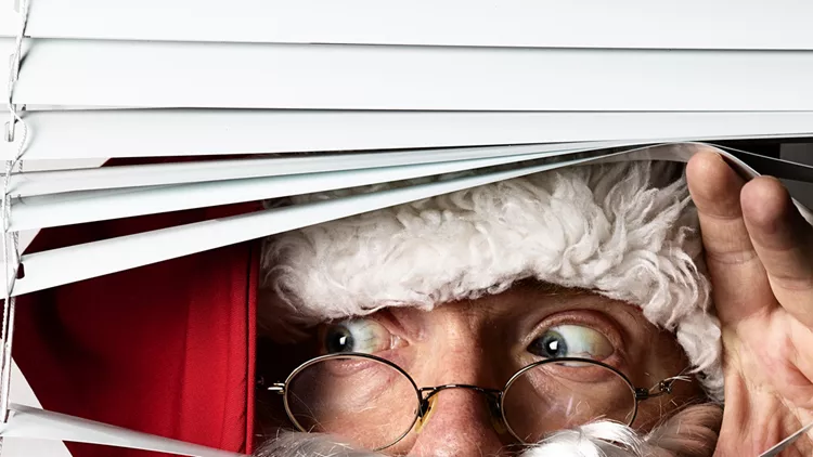 Santa Claus peeking through the blinds on a window