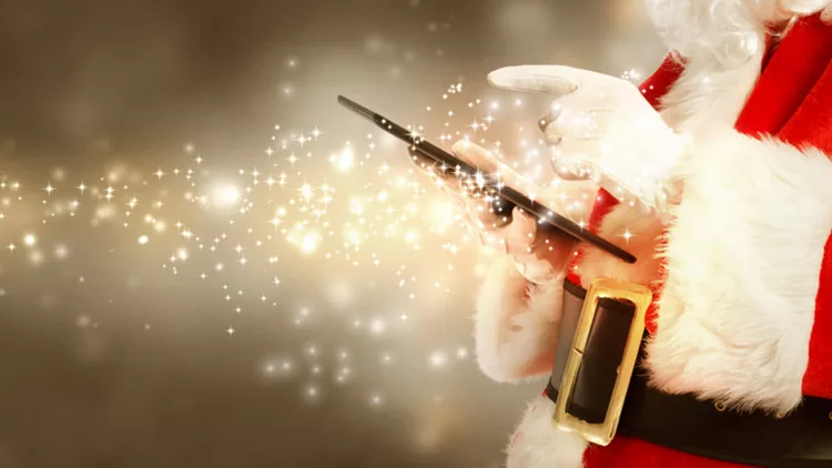 Santa Claus using tablet in snowy night