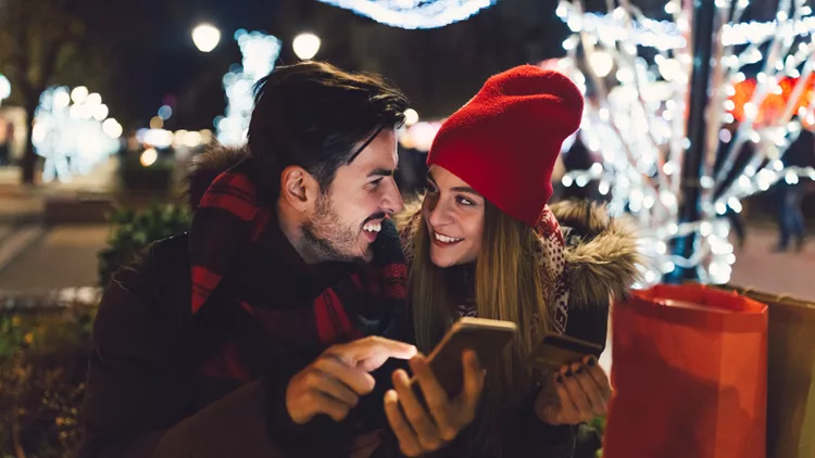 Happy couple using credit card for online shopping