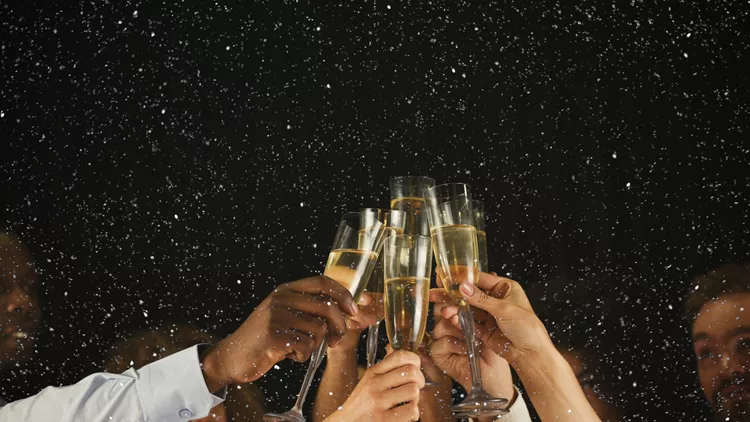 Group of young people celebrating new year with champagne at night club