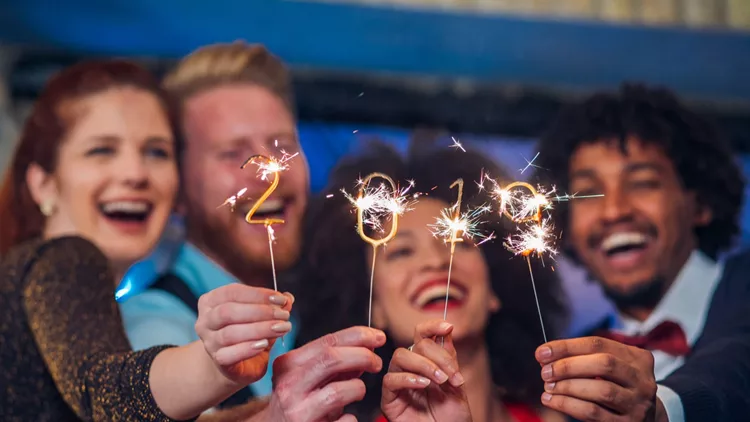 Smiling people holding sparklers