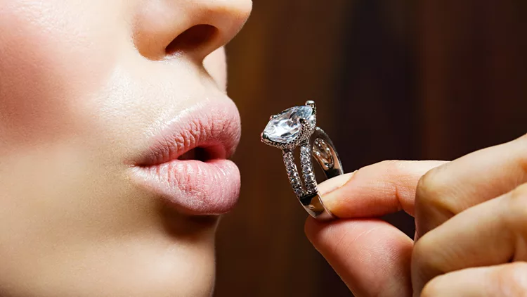 Young woman holding engagement ring