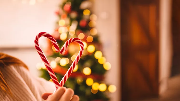 Romantic couple making heart shape with Christmas candy canes