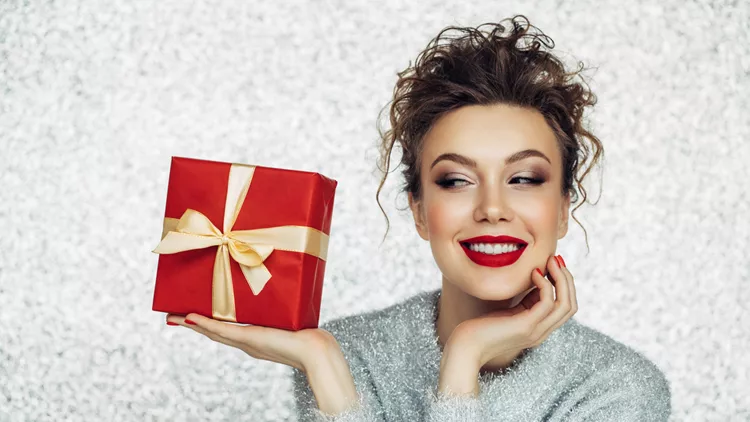 Christmas happy smiling young woman holds gift box in hands