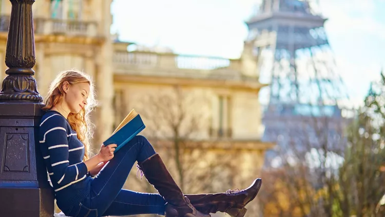 Beautiful woman in Paris, reading a book