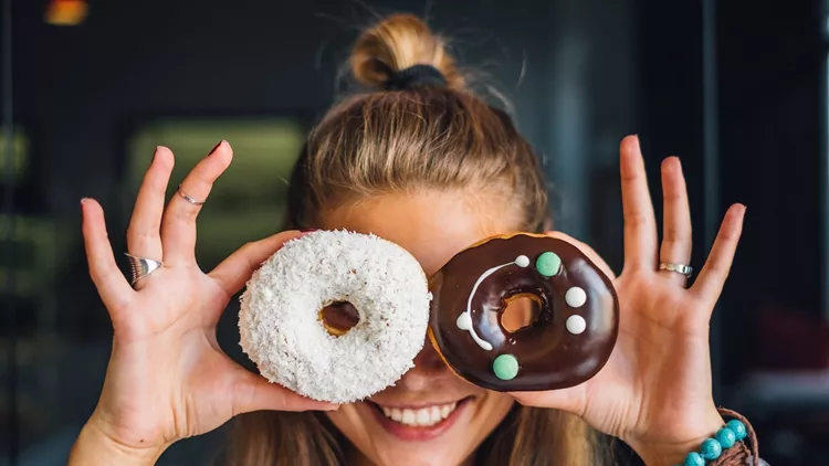 Happy woman holding donuts