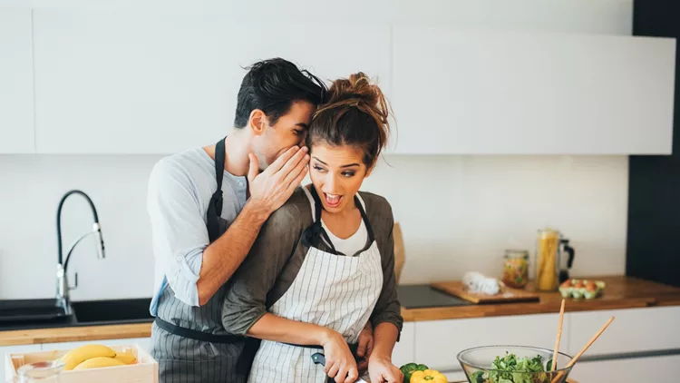 Young couple gossip in the kitchen