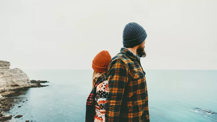 Couple lovers Man and Woman standing backs together Love and Travel happy emotions Lifestyle concept. Young family traveling romantic vacations autumn winter season