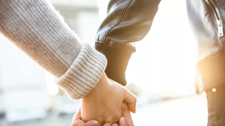 couple holding hands at arch du triomphe