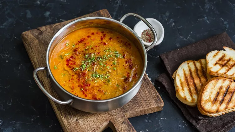 Smoked paprika vegetarian lentil soup with grilled cheese sandwiches a dark background, top view. Delicious comfort food concept. Flat lay