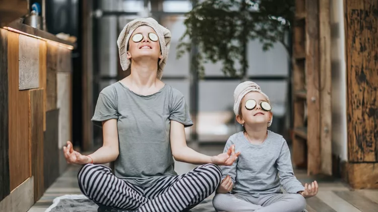 Relaxed mother and daughter exercising Yoga in the morning at home.