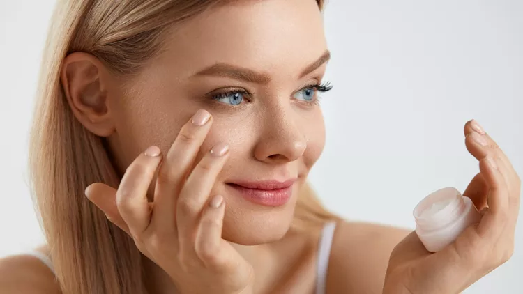 Woman Face Skin Cosmetics. Girl Applying Cream Under Eyes