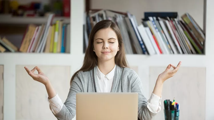 Calm relaxed woman meditating with laptop, no stress at work