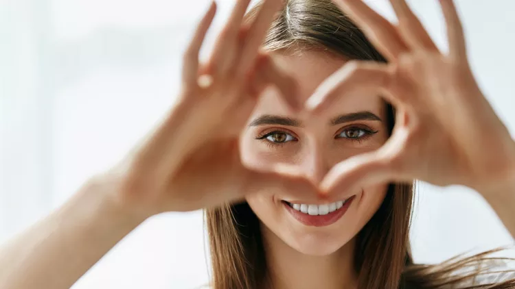 Beautiful Happy Woman Showing Love Sign Near Eyes.