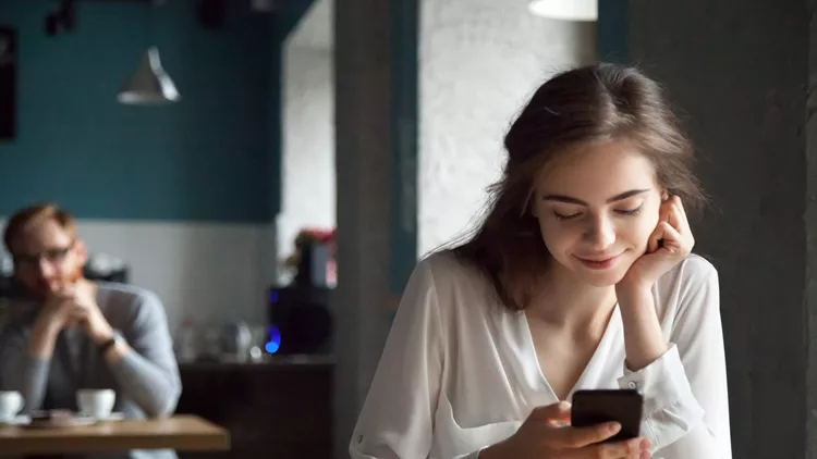 Young guy looking with interest at beautiful lady in cafe