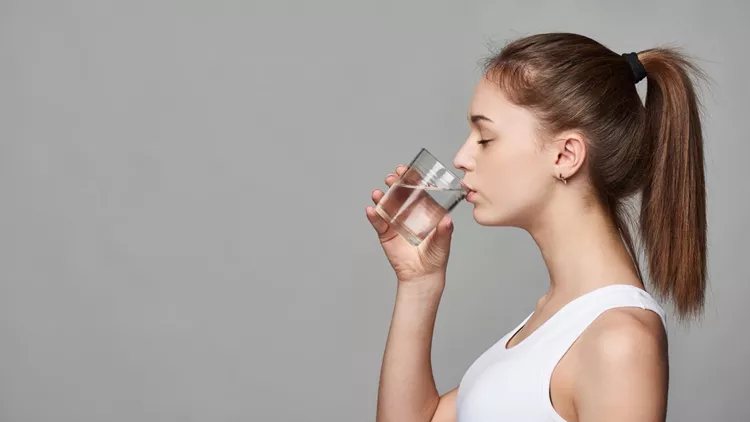 Sporty teen girl drinking water