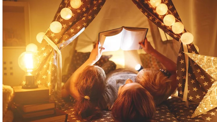 happy-family-mother-and-children-reading-a-book-in-tent-at-home-picture-id914847176