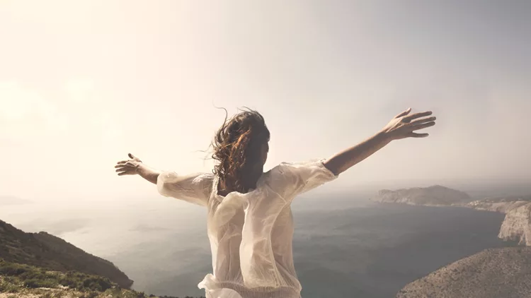 woman taking a breath in front of a spectacular view