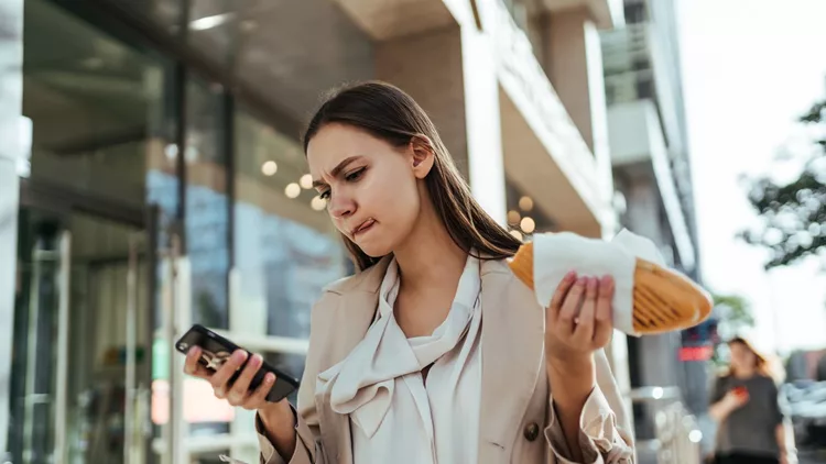 The busy businesswoman working online on a smartphone during a break