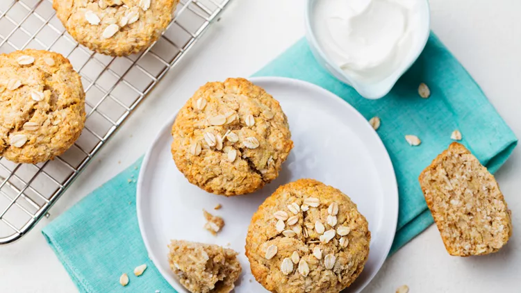 Healthy vegan oat muffins, apple and banana cakes with sour cream on a white plate. Top view.