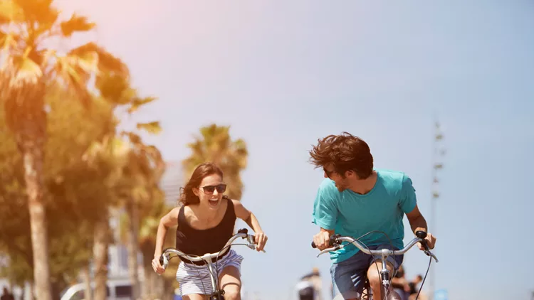 Woman chasing man while riding bicycle