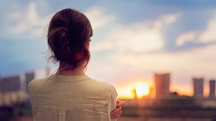 Young girl is watching sunset over Tokyo