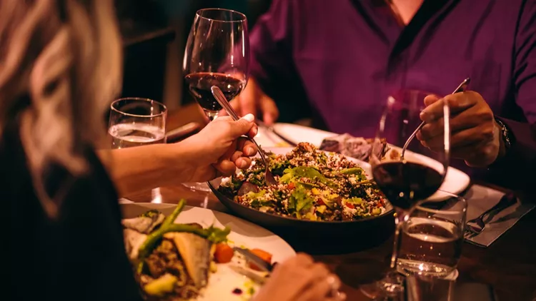 Couple eating quinoa salad and healthy dinner at restaurant
