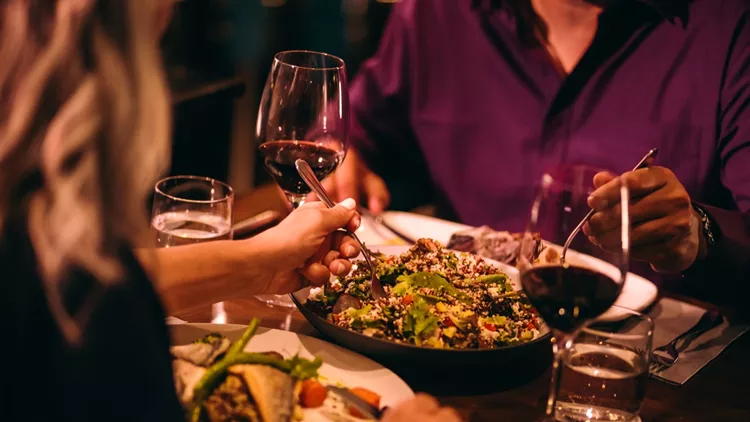 Couple eating quinoa salad and healthy dinner at restaurant