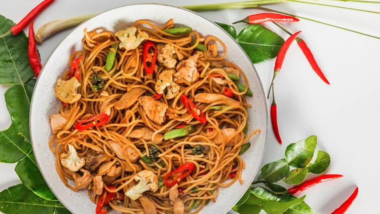 traditional spicy asian cuisine food: wok stir fry spaghetti with fried chicken