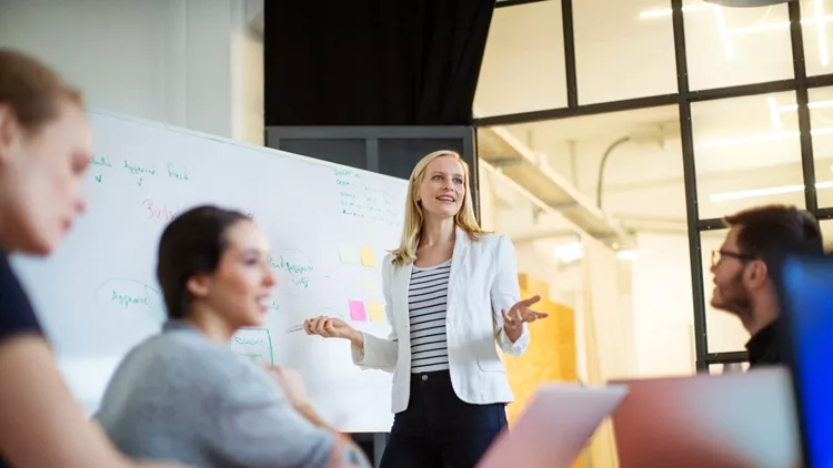 Businesswoman giving presentation on future plans to colleagues