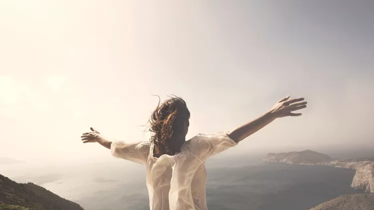 woman taking a breath in front of a spectacular view