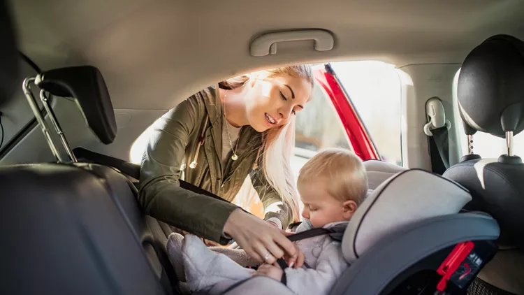 Putting Her Son in His Car Seat