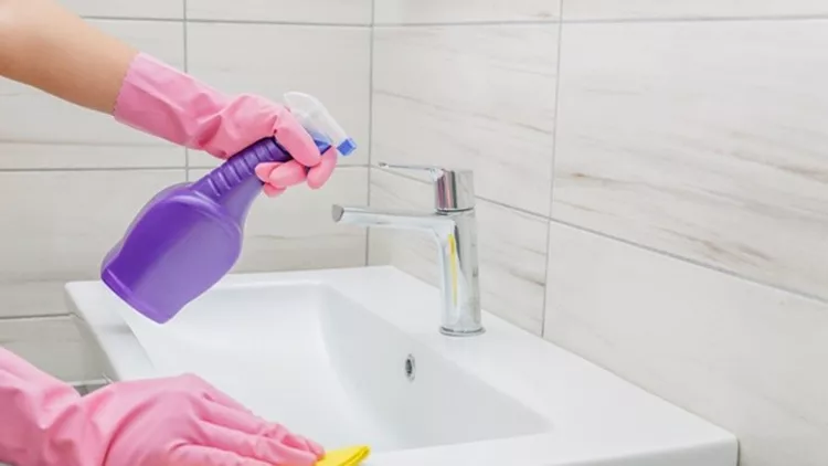 Woman cleaning bathroom at home