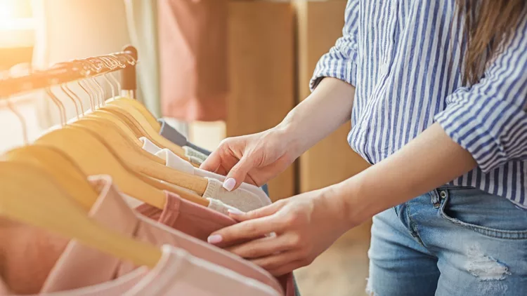 Smiling girl bying clothes in showroom