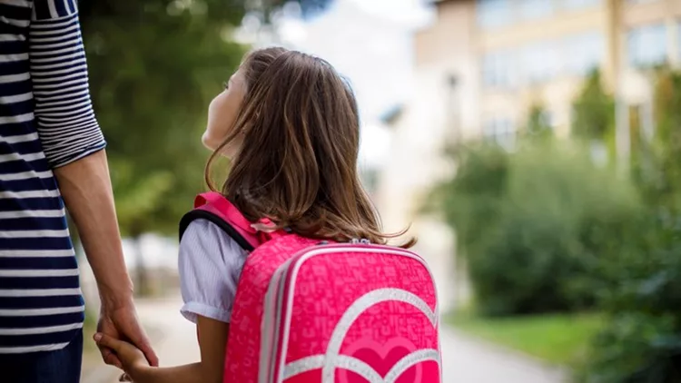 Mother taking her daughter to school