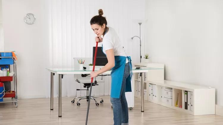 Female Janitor Sweeping Floor With Broom