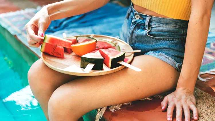 Caucasian woman eating watermelon in summertime
