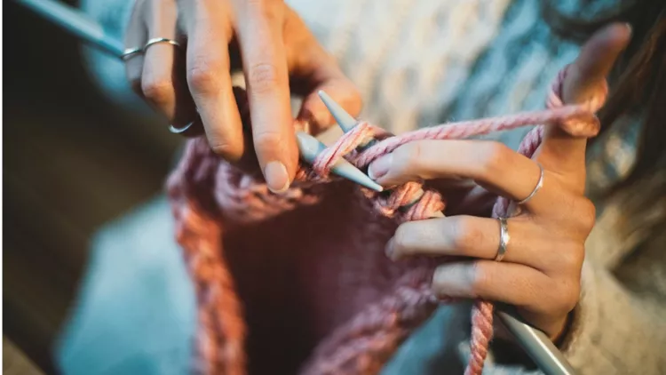 close-up-on-womans-hands-knitting-picture-id1093250302